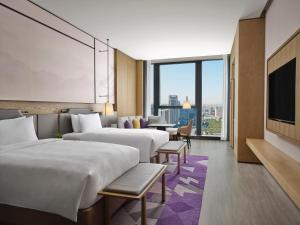 西安西安高新 JW 万豪酒店的酒店客房设有三张床和电视。