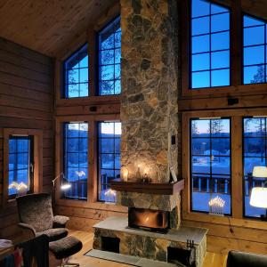 伊德勒Idre Mountain Lodge的客厅设有石制壁炉和窗户。