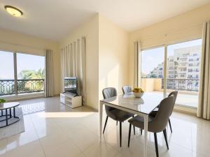 拉斯阿尔卡麦Bab Al Bahr Residence - Blue Collection Holiday Homes的一间带桌椅和电视的用餐室