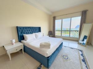 拉斯阿尔卡麦Bab Al Bahr Residence - Blue Collection Holiday Homes的一间卧室设有一张大床和一个大窗户