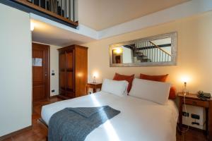 罗马洛坎达德尔科西酒店的卧室配有白色的床和镜子