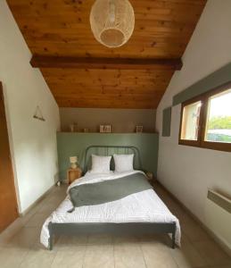 Saint-Silvain-sous-ToulxGîte de la Borderie的一间卧室设有一张木天花板床。