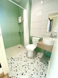 坤敬945酒店的浴室配有卫生间、盥洗盆和淋浴。