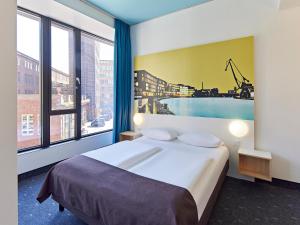 明斯特B&B HOTEL Münster Hafen的酒店客房设有一张床和一个大窗户