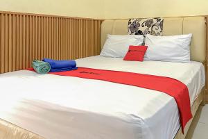 巴厘巴板RedDoorz near Wisma Cahaya Abadi Sepinggan Aiport的一间卧室配有两张带红色和蓝色枕头的床