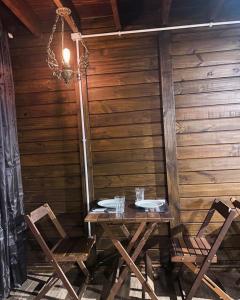 蜜岛Vilarejo Hospedagem的一张带两把椅子和吊灯的木桌