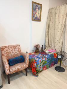 Chu-nan-ts'unㄧ個背包客棧的一间卧室配有椅子和一张带毯子的床