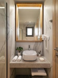 托罗尼Eco Green Residences & Suites的一间带水槽和镜子的浴室