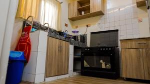 阿布贾House 575的厨房配有黑色烤箱和木制橱柜。