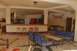 恩加帕鲁Hotel Takana的客厅设有蓝色椅子和酒吧