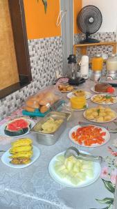 伊尔哈德博伊巴Pousada & Kitnet Nascer do Sol的一张桌子上放着许多盘子的食物
