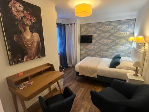奥朗日Le Clos d'Orange, Hotel & ville de Provence的卧室配有一张床,墙上挂有绘画作品