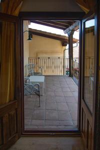夸科斯德尤斯特亚巴迪亚德乌斯特乡村酒店 的通往带桌椅的阳台的开放式门