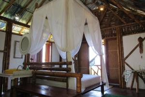巴伊亚福尔莫萨Pousada Sabambugi的一间卧室配有白色窗帘的床