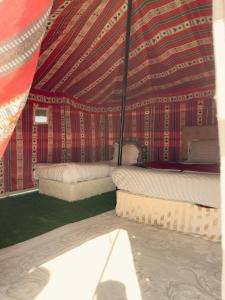 Al WāşilHamood desert local camp的帐篷内带两张床的房间