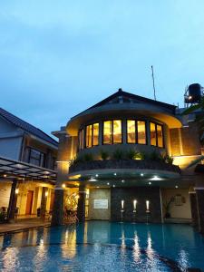 马格朗斯睿提马格朗酒店的一座大型建筑,前面设有一个游泳池