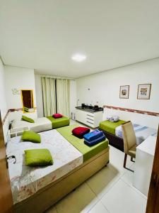 瓜鲁柳斯H34 Hotel的酒店客房配有两张床和一张书桌
