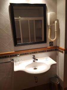 蒙福特·德·莱蒙斯Hotel Condes De Lemos España的一间带水槽和镜子的浴室以及一部电话