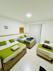 瓜鲁柳斯H34 Hotel的绿色和白色的客房内的三张床
