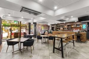 阿德莱德Econo Lodge North Adelaide的一间带桌椅的餐厅和一间酒吧