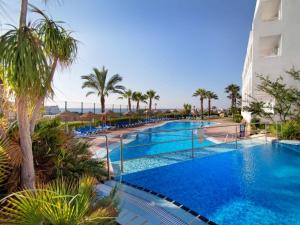 莫哈卡尔瑟维集团玛丽娜玛尔酒店的一座棕榈树游泳池和一座建筑