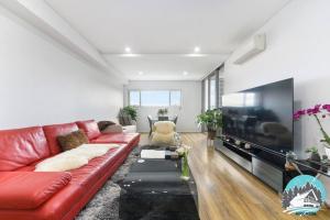 悉尼Aircabin - Burwood - Sydney - 2 Beds Apt Free Park的客厅配有红色沙发和大电视