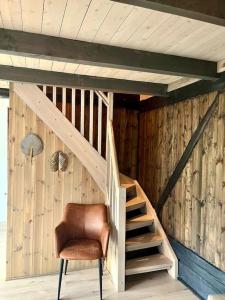 Hus ved Valsøyfjorden的木楼梯,房间带棕色椅子