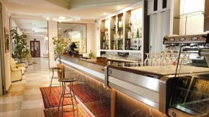 阿尔盖罗圣马可酒店的一间酒吧,里面设有柜台和凳子