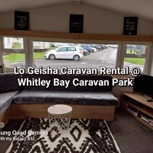 惠特利湾Lo Geisha Caravan Rental at Whitley Bay Caravan Park的停车场内的一个有篮球架的房间