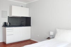 海德堡Hometown-Apartments的白色的厨房配有水槽和床
