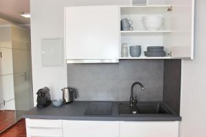 海德堡Hometown-Apartments的厨房配有水槽和白色橱柜