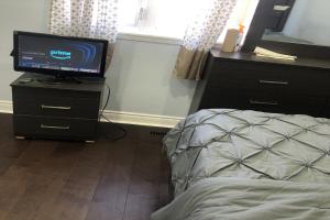 皮克灵ShayCozyDelux-Room-201的一间卧室配有一张床,梳妆台上配有电视