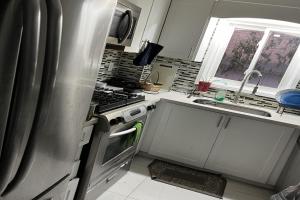 皮克灵ShayCozyDelux-Room-201的厨房配有不锈钢冰箱和水槽