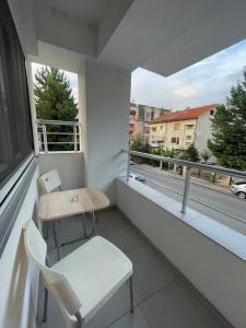 斯科普里Two bedroom Apartment in Skopje Center的阳台配有桌子、椅子和窗户。