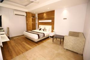新德里Hotel Stanley- Near Delhi Airport的一间卧室配有一张床和一把椅子