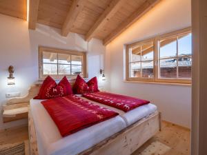布里克森谷地霍普夫加尔滕Ferienhaus Weberhof的一间卧室配有一张带红色枕头的大床