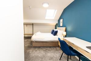 奥尔德姆Suite 7 - Family Room in the Heart of Oldham的一间卧室设有一张床和蓝色的墙壁