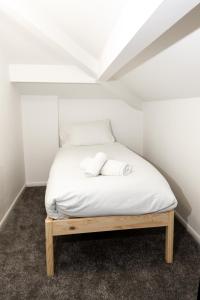 奥尔德姆Suite 7 - Family Room in the Heart of Oldham的一张位于小客房内的床铺,配有白色床单