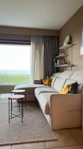 德帕内Superbe studio avec une magnifique vue sur la mer.的客房设有两张床、一张沙发和一个窗口。