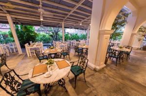 卡伦海滩The Old Phuket - Karon Beach Resort - SHA Plus的一间带桌椅的用餐室和大窗户