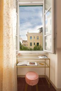 罗马G & G Maisonette Testaccio的窗户前的窗户,带桌子和凳子