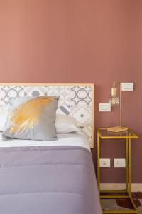 罗马G & G Maisonette Testaccio的一张带枕头的床和一张带台灯的桌子