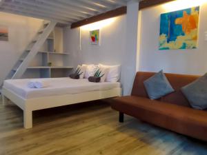 八打雁Coco Cavana Resort的卧室配有白色的床和沙发