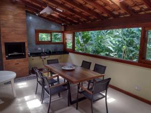 乌巴图巴CASA PRUMIRIM的一间带木桌和椅子的用餐室