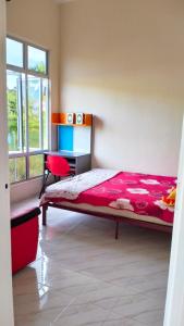 TumpatHomestay Dena Moon Inn的一间卧室配有一张床、一张书桌和一个窗户。