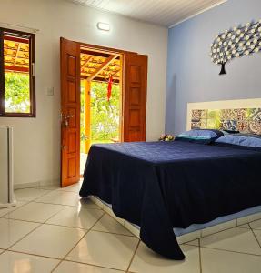 库穆鲁沙蒂巴Villa Mar a Vista - Suite Alamanda的一间卧室设有蓝色的床和一扇门