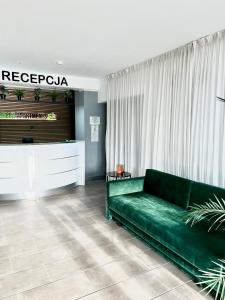 霍茹夫Green Apartments Katowice Chorzów的客厅配有绿色沙发和电视
