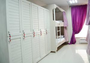 比什凯克MY HOSTEL的卧室设有白色门和紫色窗帘