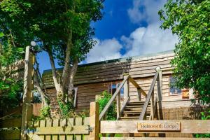 彭赞斯Helnoweth Lodge的木屋设有楼梯和木栅栏