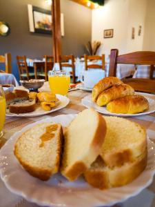 伊瓜苏港伊瓜苏阿尔图斯酒店的一张桌子,上面放着三盘面包和橙汁